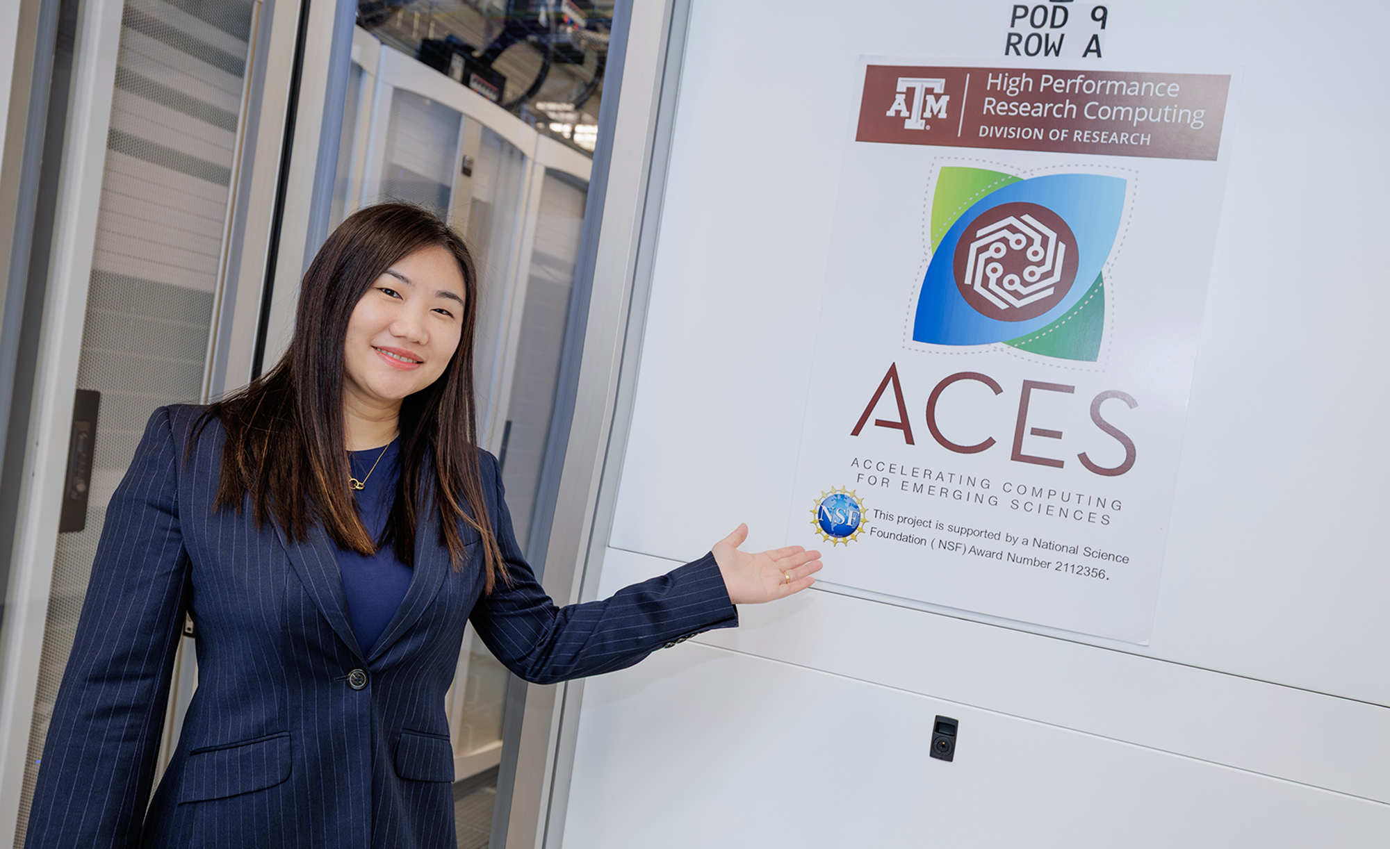 Dr. Zhe Zhang from Texas A&amp;M gestures toward an ACES project poster, part of the High Performance Research Computing division under the university’s Division of Research.