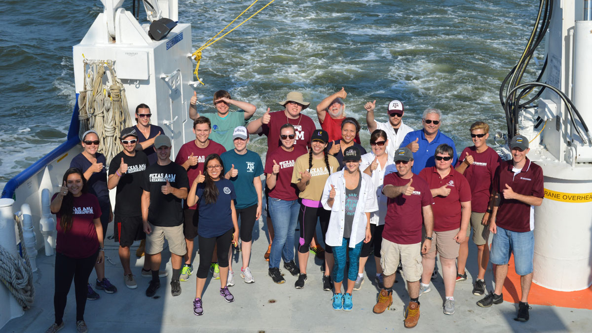 Large group of students posing for a picture on a research vessel 