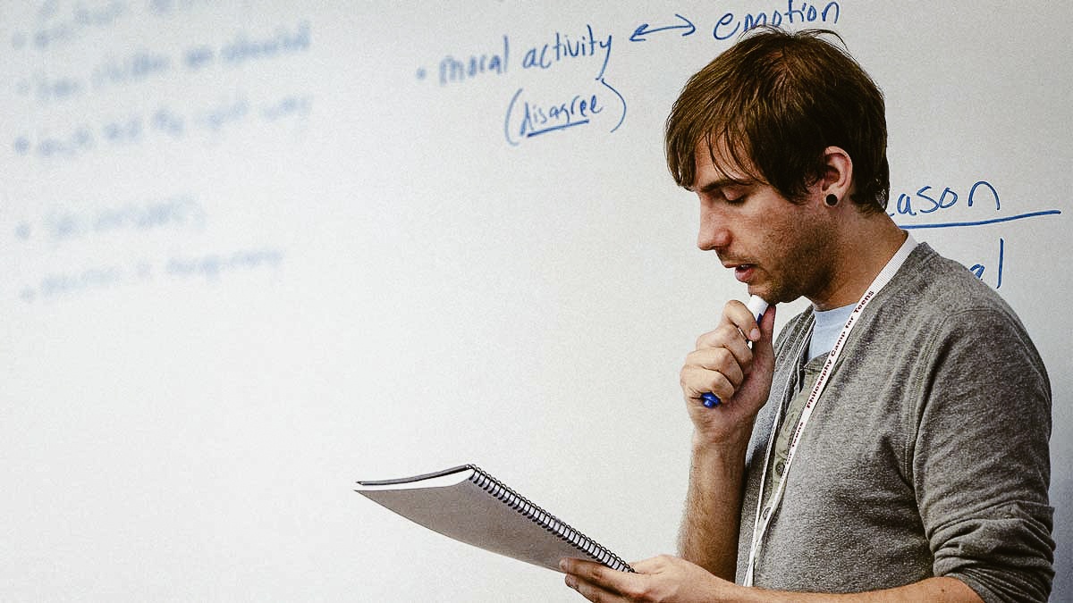 man thinking in front of a white board