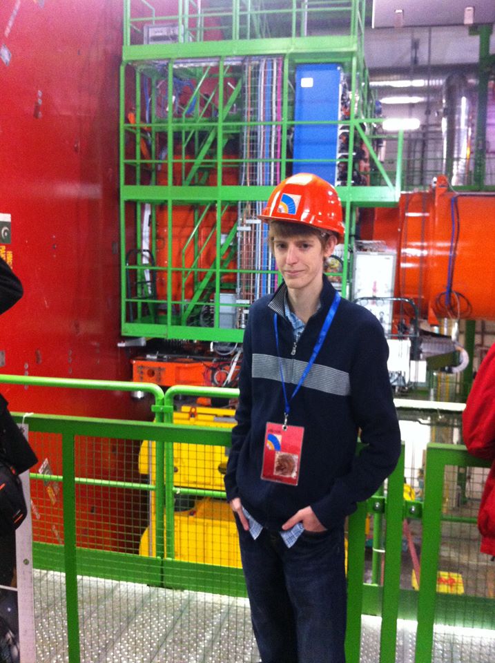 Austin Baty wearing a hard hat and exclusive pass while working with particle accelerator.