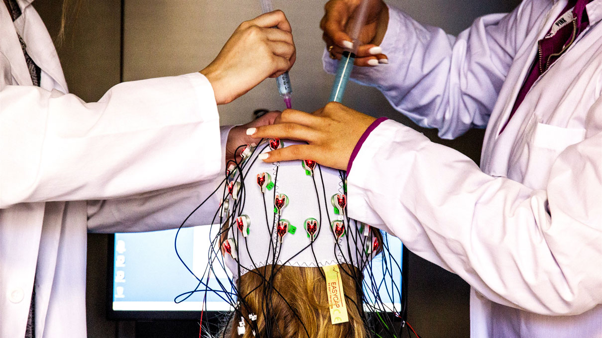 Researchers setting up a brain scan apparatus 