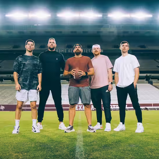 The five members of Dude Perfect stand upon the turf at Kyle field
